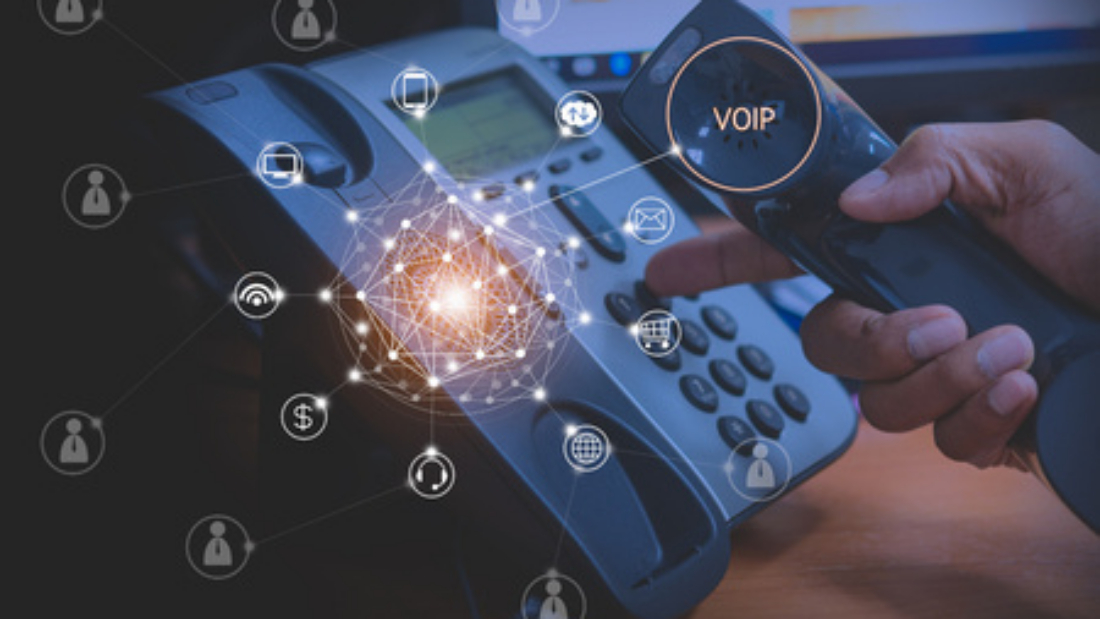 Hnad of man using a VoIP phone system and VoIP network