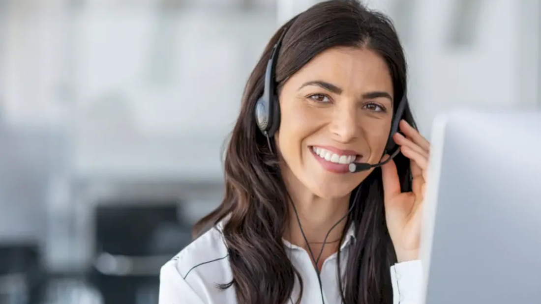 Woman in call center smiles as she talks into headset