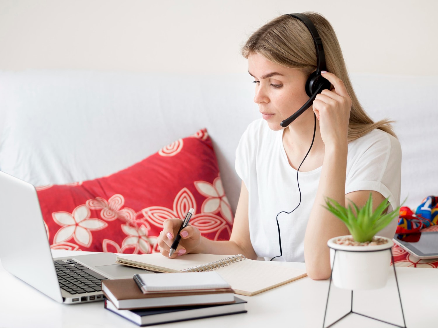 A woman working remotely from home, using a soft phone system for scalable communication.