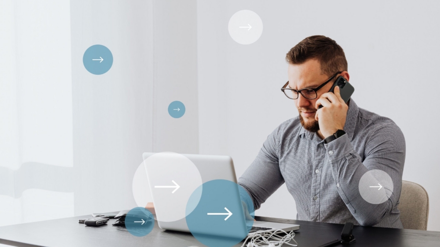 Professional man multitasks with laptop and smartphone in home office environment.