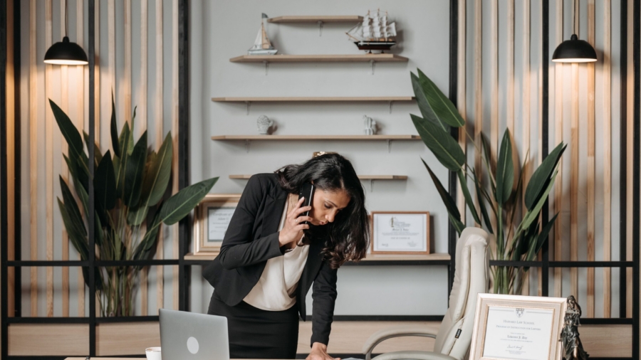 A professional woman lawyer multitasking in a modern office environment, reviewing documents.